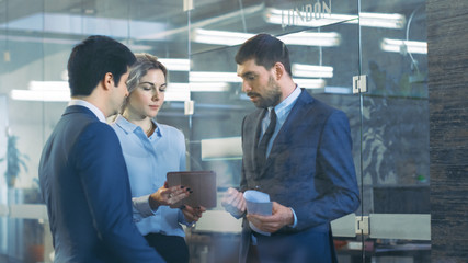 Team of Male and Female Diplomats and Business People Talking, Using Tablet Computer. High Class Corporate Building.