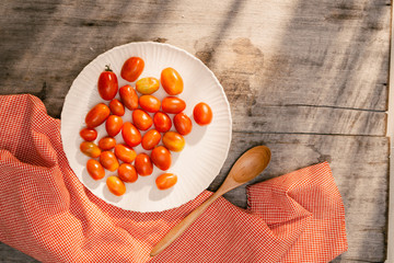 white dish with cherry tomatoes on wooden tabl