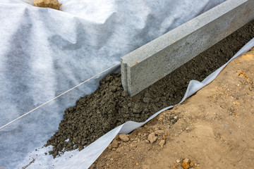 Setting of edge restraints with border stones in concrete