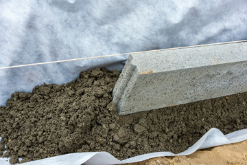 Setting of edge restraints with border stones in concrete