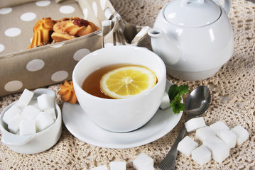 White cup with lemon tea, cookies for a nice afternoon