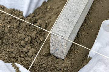 Setting edge restraints with border stones in concrete - 210799974