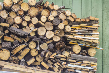 Wood logs background. Chopped firewood on the background of the fence