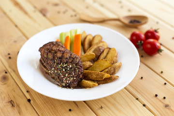 Meat cooked on the grill in seasonings. Garnish with potatoes and vegetables