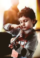 Child playing violin. Learning concept.