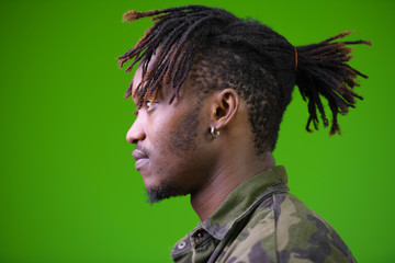 Young handsome African man with dreadlocks wearing camouflage shirt