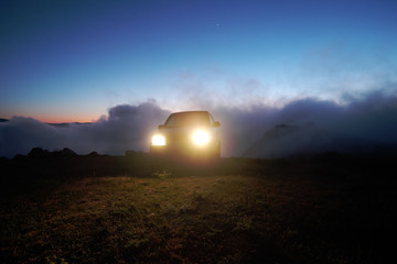 Off-Road Car Over The Clouds At The Twilight