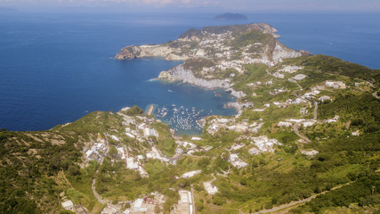Aerial view of the beach and the small harbor of Cala Feola on the island of Ponza, in Italy. There are many boats and motorboats of tourists anchored in the bay and sheltered in the mountains.
