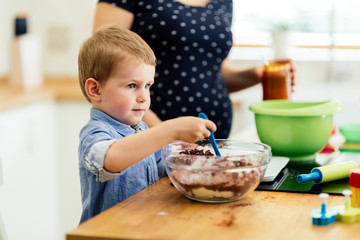 Child helping mother make cookies