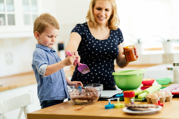 Obraz na płótnie Canvas Smart cute child helping mother in kitchen
