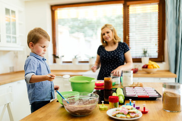 Obraz na płótnie Canvas Smart cute child helping mother in kitchen