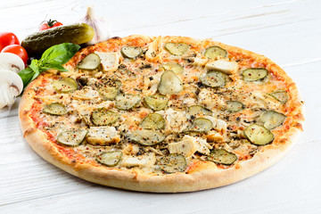 Appetizing hot Italian pizza with cheese, mushrooms and cucumber