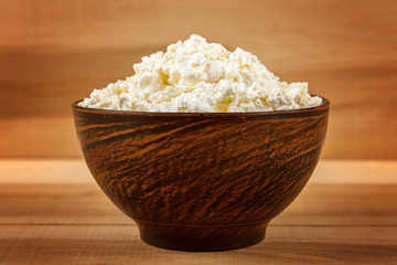 Fresh cottage cheese in a white bowl with spoon