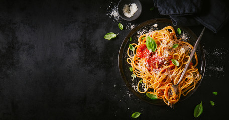 Fototapeta Dark plate with italian spaghetti on dark obraz