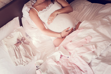 Attractive pregnant woman is sitting in bed