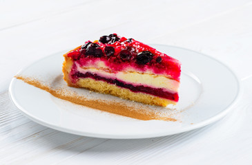 Piece of sweet delicious cherry cheesecake on white plate on whi