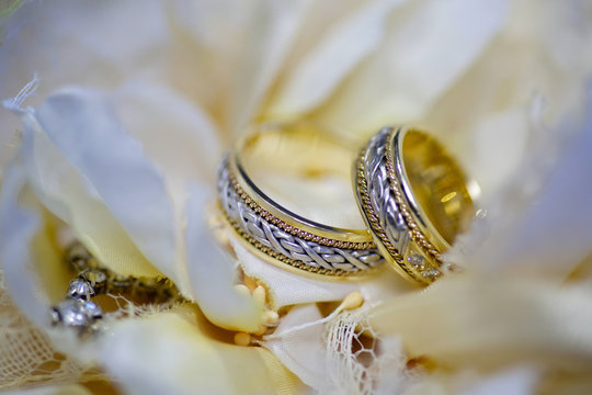 Wedding rings made of metal lie on a beautiful bouquet of fresh flowers. The concept of holidays and ceremonies.