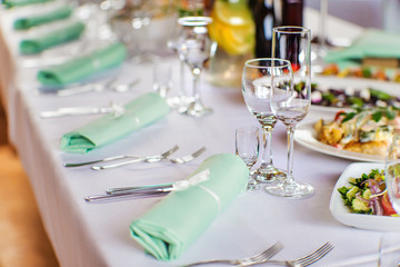 Table with a white napkin, glasses and cutlery prepared for a banquet.