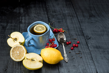 A cup of tea with lemon on black background