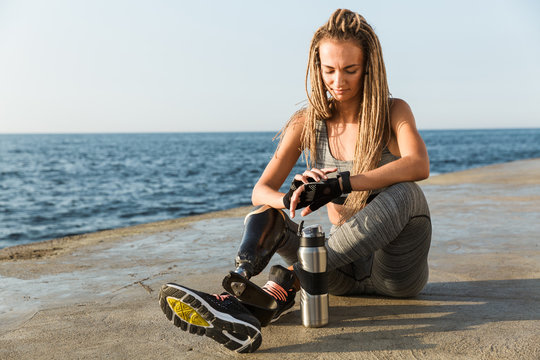 Smiling disabled athlete woman with prosthetic leg - Powered by Adobe