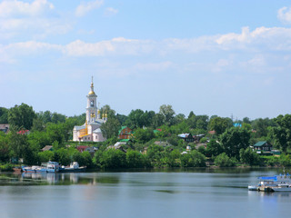 Fototapeta premium Small towns of Russia. Kimry, Tver region. Panorama of the city with Lord's ascension temple and wooden houses on the bank of the Volga river.