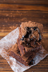 Homemade brownies on dark moody background. Chocolate cake closeup. Copy space.