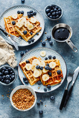 Waffles with banana and fresh blueberries.