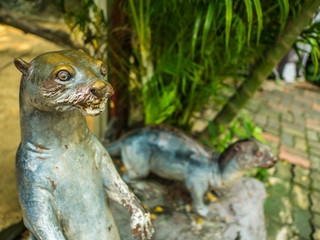 Two otter Statue one stand and one Crawl on the floor in The zoo bangkok thailand,otter Statue in front of otter area in The zoo bangkok 