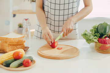 Young woman cutting vegetables in kitchen