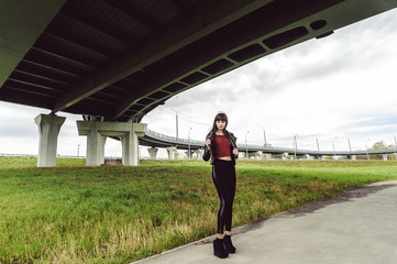 young beautiful stylish woman in fashionable black clothes, a burgundy cardigan and a dark leather...