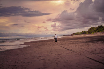 Fototapeta na wymiar back view of man riding motorcycle on ocean beach