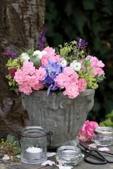 Dekoration mit Blumenstrauß in Pink und Lila und Kerzen