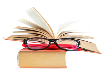 Open book and glasses on a stack of books