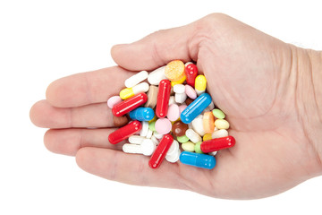 Pills, capsules in hand on white. Medicines and drugs.