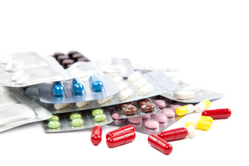 Pills in blister packs on white background.