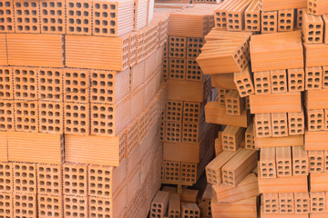 Stack of red clay brick. Warehouse. Storage of products made of bricks.