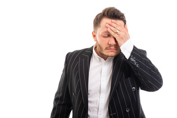 Portrait of business man showing headache gesture.