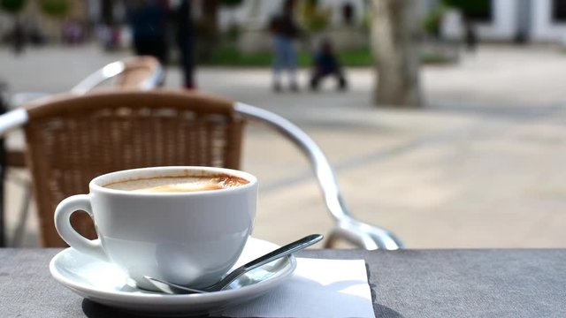 relaxing coffee in the foreground with everyday life going on in the background