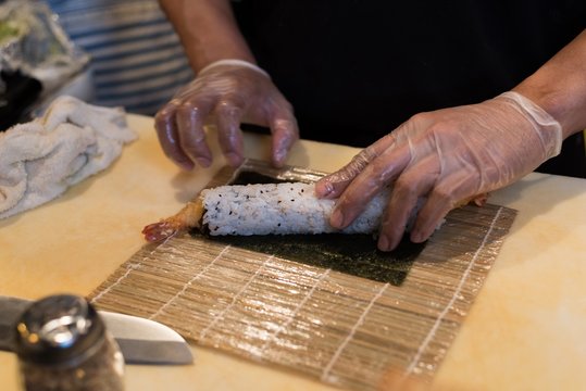 Chef rolling unrolled sushi