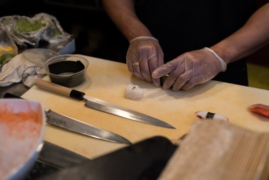 Man's hand preparing sushi