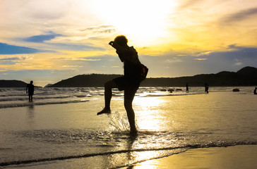 Relax on the beautiful sunset beach on Koh Chang, Thailand. Silhouette at people on the ocean beach at sunset on the beach. The beauty of the people who are enjoying the sunset on the beach, Thailand.