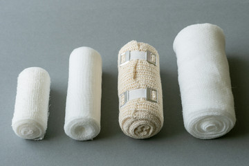 Fototapeta na wymiar Different sizes of medical bandages. Medical bandages on grey background. Medical equipment.
