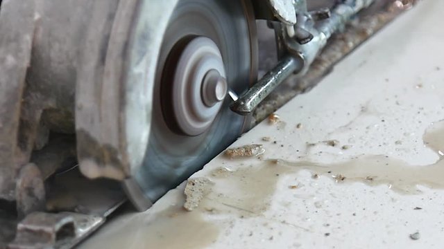 4K video of worker working with cutting tile saw for cutting stone marble tile