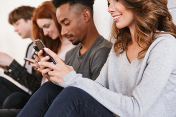 Friends students sitting over white wall