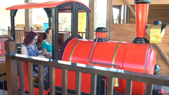 Amusement park. Women are sitting in a train. Roller coaster