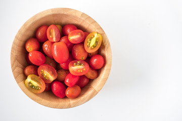 Plum tomatoes in wooden bowl on white background. copy space