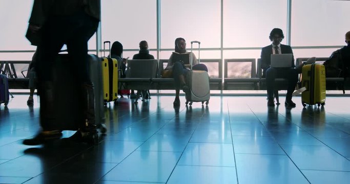 Multi-ethnic crowd of people at airport gate waiting room