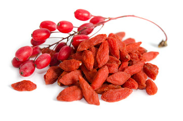 Branch of ripe red barberries and dried goji berries isolated on white background