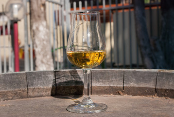 White semi-sweet wine in a glass, on old vintage wooden barrel