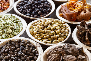 Group of indian spices in coconut bowls on wooden background